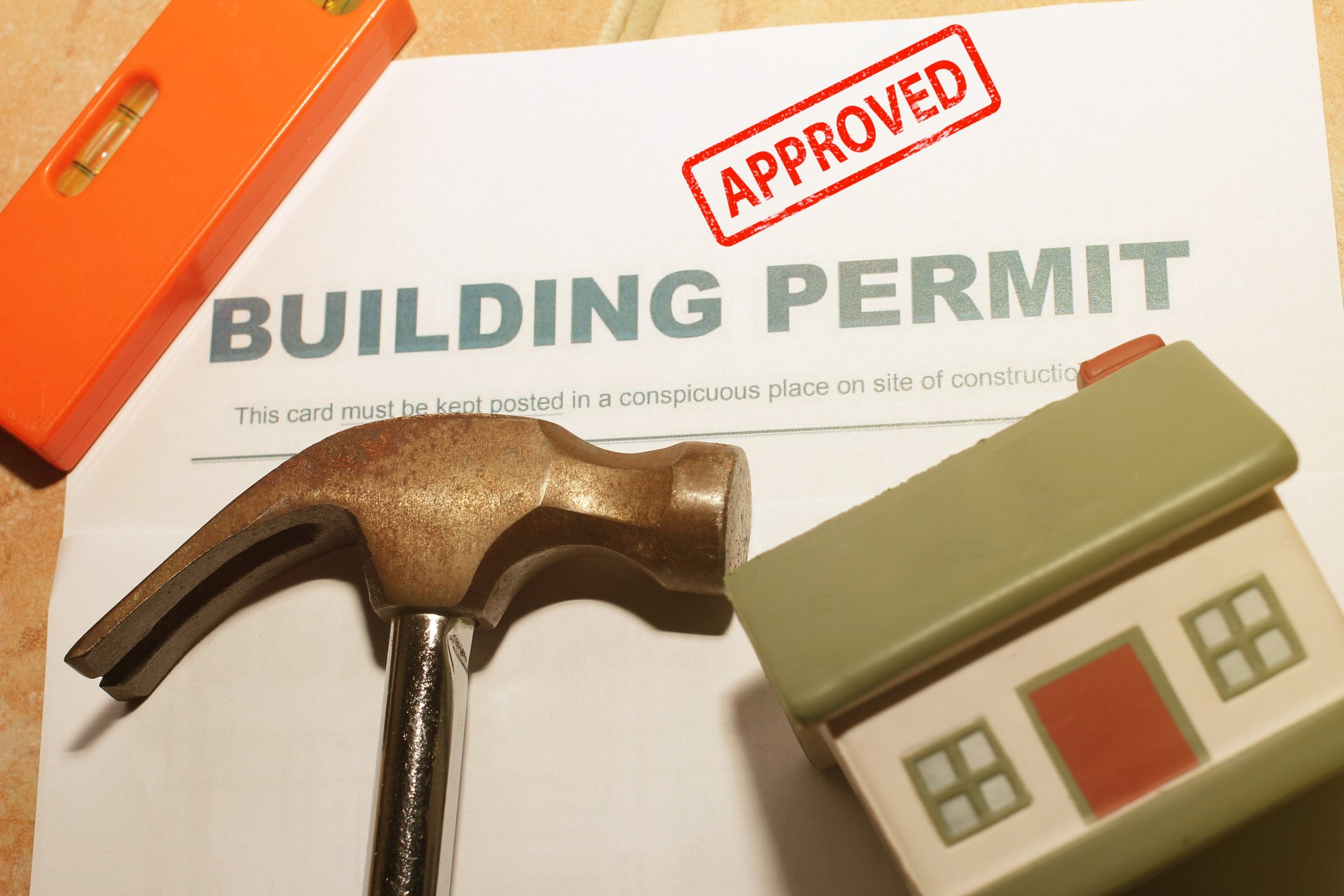 An approved building permit document with a hammer and model house